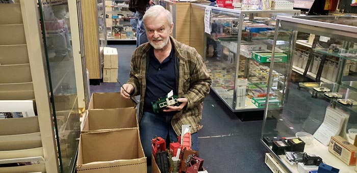 Frank Gustafson, owner of the Jackson Hobby Shop, packs up some miniature trains during the last day of operation of the business which noted a half century of operation this year. (Photo by Bob Vosseller)