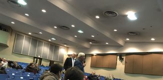 A resident asks about the reduction in state aid, as Superintendent David Healy brings the microphone to audience members. (Photo by Chris Lundy)