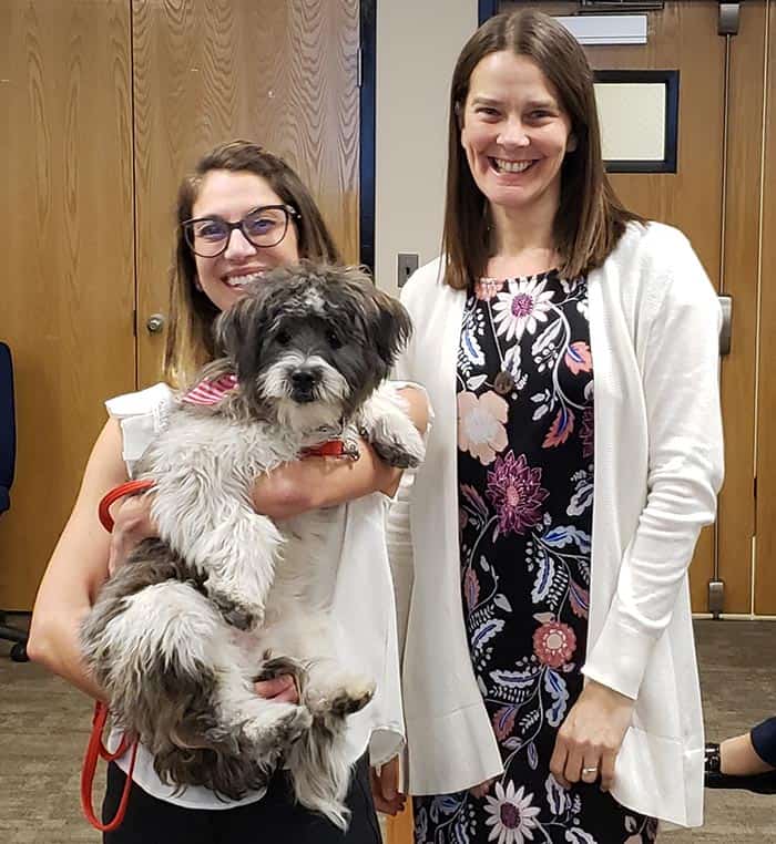 Howard C. Johnson Elementary School music teacher Melissa O’Keeffe holds “Mighty” the school’s new therapy dog as she stands beside Library Teacher Carrie Hogan who hosts the dog who comes to the school once a week. (Photos by Bob Vosseller)
