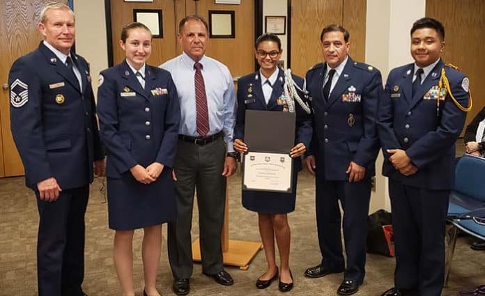 Board member Thomas Colucci (third from left) joins Air Force Major Michael Macagnone, far left and Senior Master Sgt. Charles Latimer (second from right) in recognizing the district’s ROTC Unit. Holding the certificate is Cadet Hannah Mahabir. (Photo by Bob Vosseller)