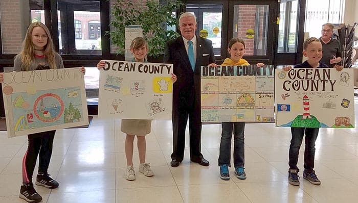 Ocean County Clerk Scott M. Colabella poses with the poster contest winners. (Photo courtesy Ocean County)