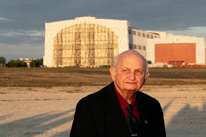 Carl Jablonski, Navy Lakehurst Historical Society president, stands with Hangar One in the background. (Photo by Jennifer Peacock)