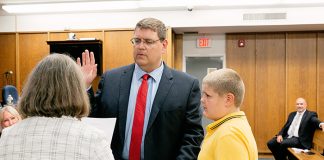 Robert Hudak, with his son Michael holding the family Bible, was sworn in as councilman by clerk Marie Key on May 28. (Photo by Jennifer Peacock)