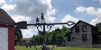 Weathervane temporarily on table with barn on left and Lizzie Herbert Gift Shop on right at Havens Homestead Museum property, 521 Herbertsville Rd., Brick. (Photo courtesy Brick Historical Society)