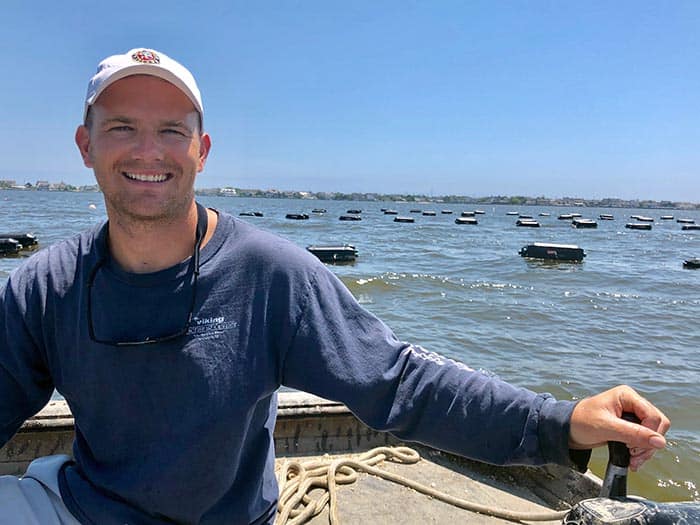 Oyster farmer Tommy Burke steers his boat around the 200 oyster cages floating in the bay. (Photo by Judy Smestad-Nunn)